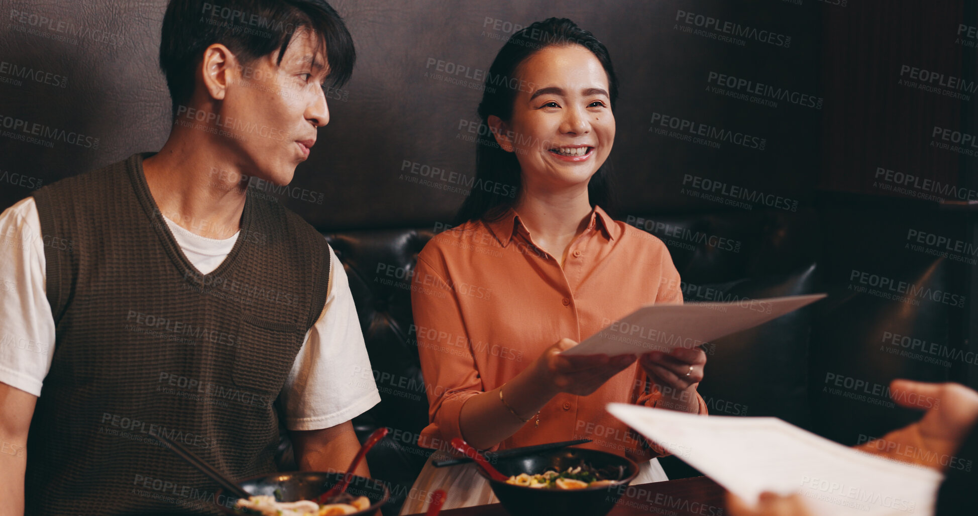 Buy stock photo Japanese couple, menu and happy at restaurant with order, meal and choice on date with partner. People, woman and man with paper for catering list, decision and customer with services at diner