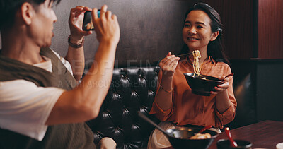 Buy stock photo Couple, food and photo on date in restaurant for happy memory, profile picture update and social media post. Japanese people, ramen bowl and smile with video recording in cafe for bonding and dining