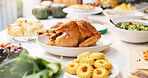 Table dinner and celebration with food for thanksgiving, nutrition and holiday for gratitude at home. Closeup, meal and dish for supper with turkey, vegetables and dessert for festive feast in house