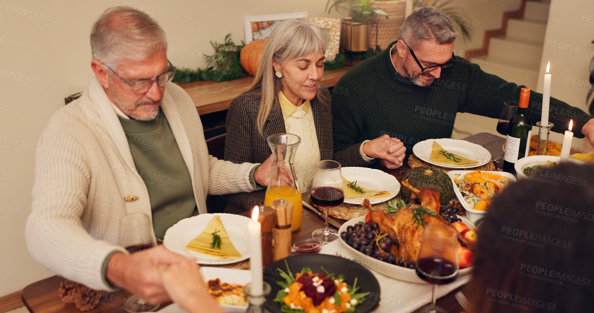 Buy stock photo Thanksgiving, people and holding hands with prayer for food, festive feast and celebrate at home. House, christian family or meal with grace for spiritual connection, blessing or grateful with dinner