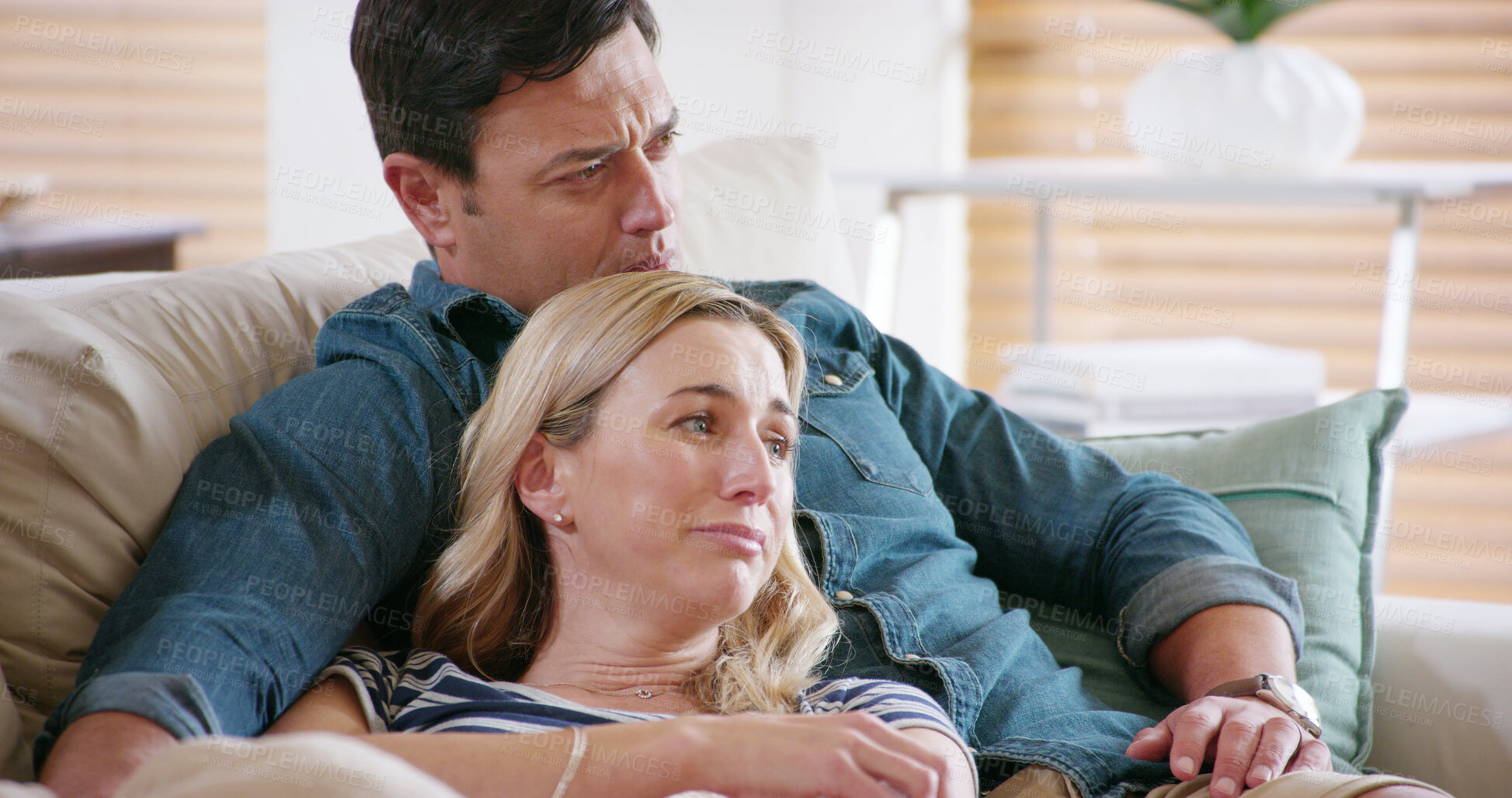 Buy stock photo Watching TV, relax and couple crying on sofa for bad news, sad movie and support in home. Man, woman or emotional in living room with empathy, heartbroken or streaming media with care in relationship