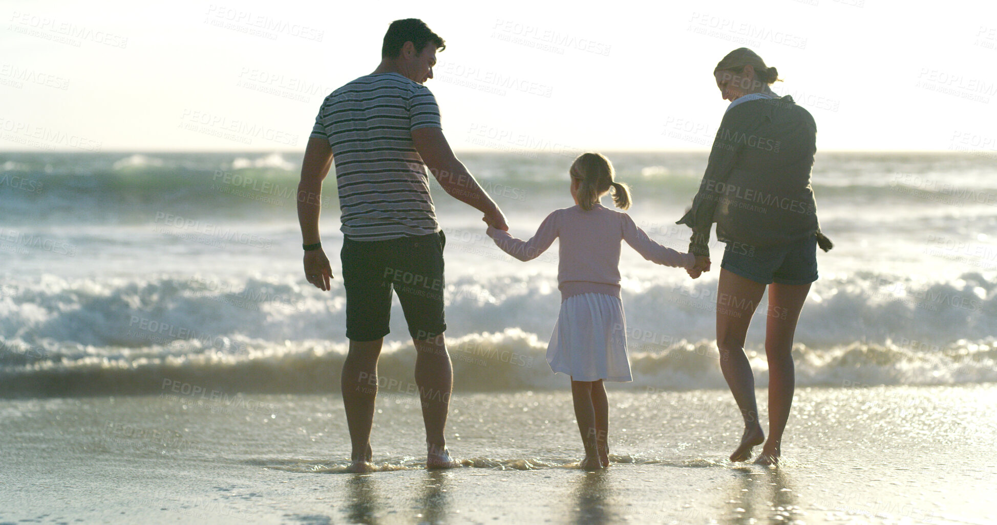 Buy stock photo Holding hands, family and vacation to relax, beach and waves in morning, bonding and child with parents and love. Holiday, water and people with daughter, back and care for kid, sea and California