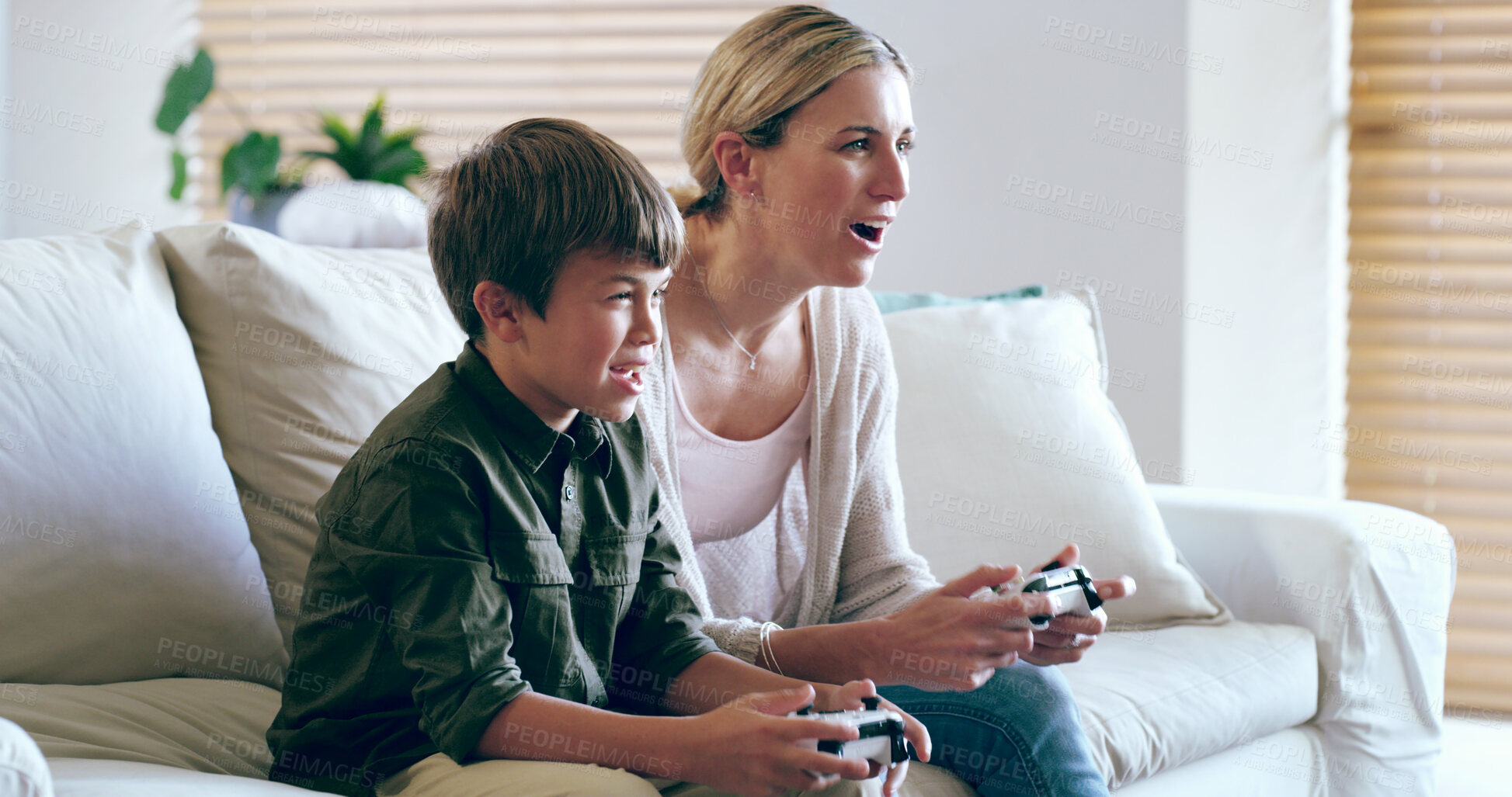 Buy stock photo Playing, mom and son in living room, video game and bonding with tech, fun and competitive in house. Lounge, gamer and woman with console, kid and subscription for happy family, electronics and home