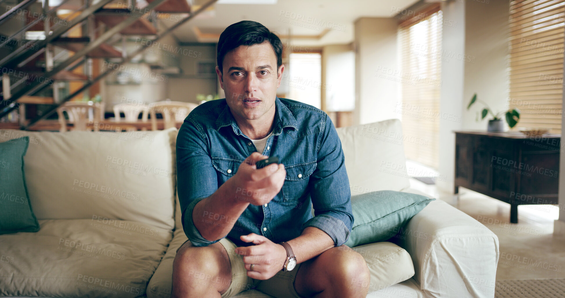 Buy stock photo Watching tv, game and remote with man, nervous and live streaming sport on living room sofa. Competition, lounge and fan with entertainment, waiting and anticipation for winning goal in match 