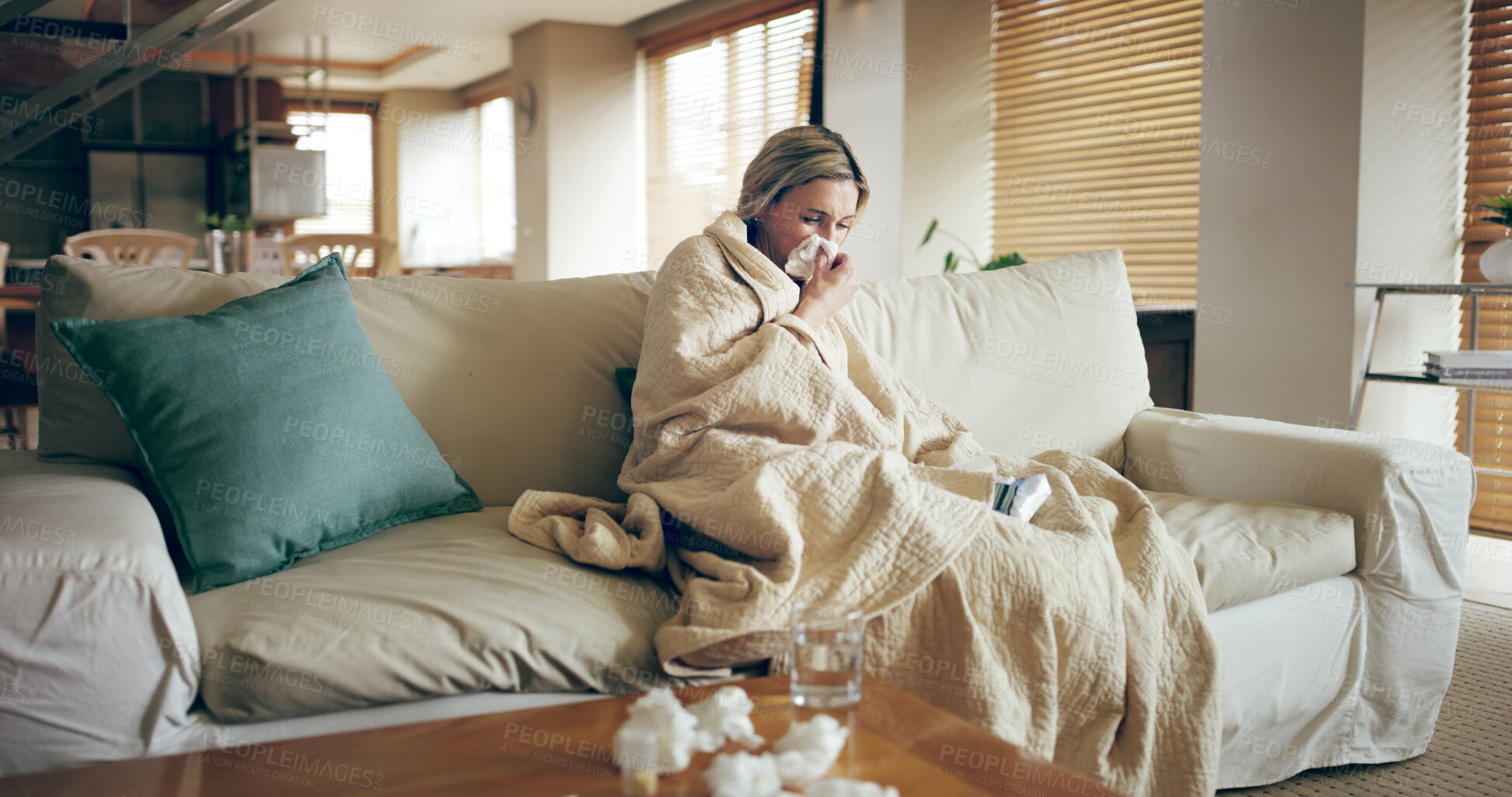 Buy stock photo Woman, sick and blow nose on sofa with tissues, Covid 19 symptoms and flu season in home. Person, blanket and self care in living room with virus, spring allergies and sneezing with medical condition