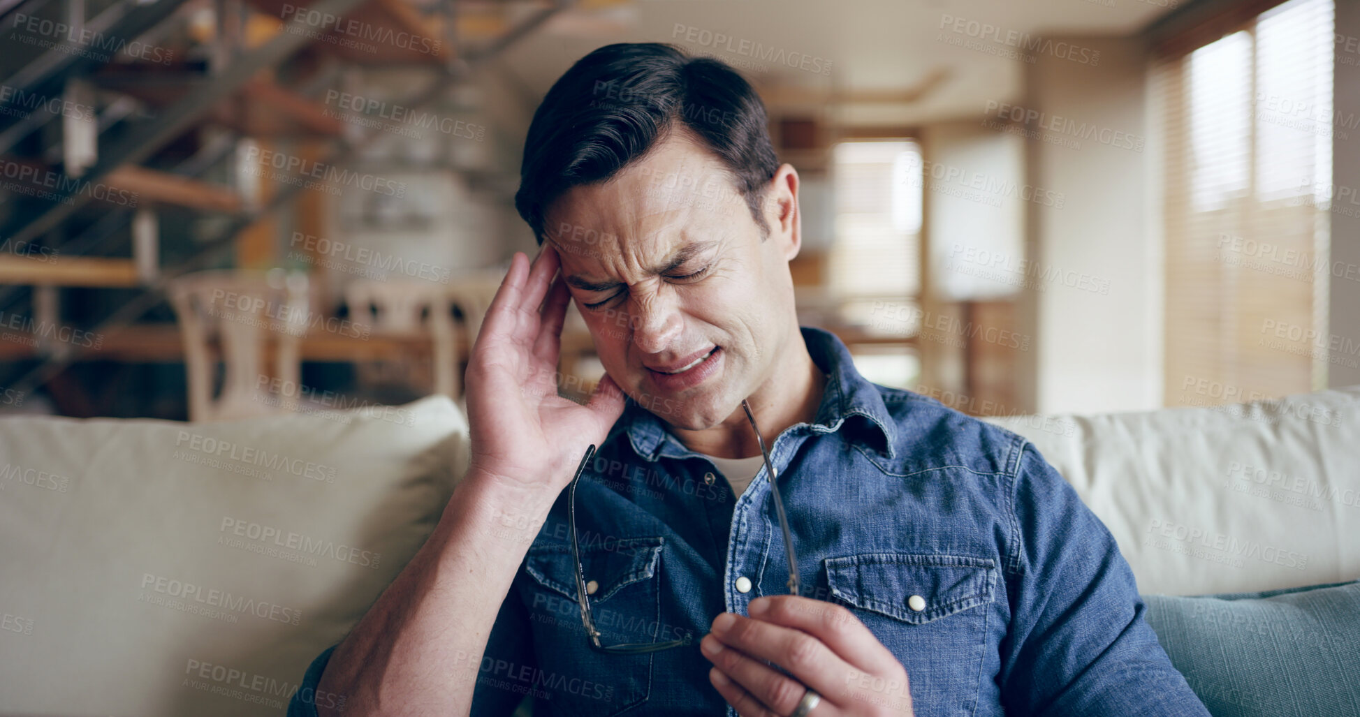 Buy stock photo Man, stress or headache in home with glasses, sickness and medical condition on sofa. Male person, migraine or eye strain in living room for emergency, anxiety or massage temple for relief of illness