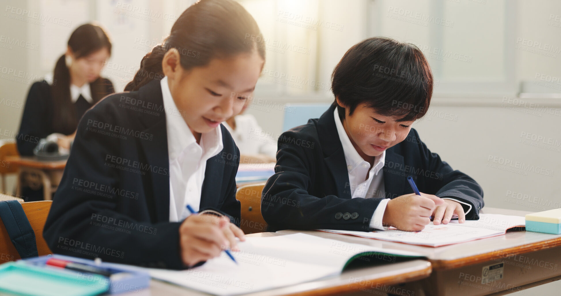 Buy stock photo Children, books and writing in classroom with learning, smile or progress with development at academy. Kids, notes and  happy with studying, scholarship or assessment with solution at school in Japan