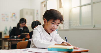 Buy stock photo Boy, book and writing in classroom with smile, learning and progress with development at academy. Kid, notes and  happy with studying, scholarship and assessment with education at school in Japan