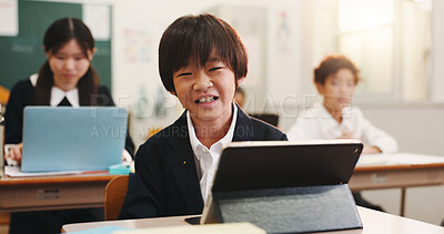 Buy stock photo Boy, child and happy in classroom with tablet, portrait and excited for e learning, development and progress. Learner, school kids and touchscreen for education, smile and study at academy in Japan