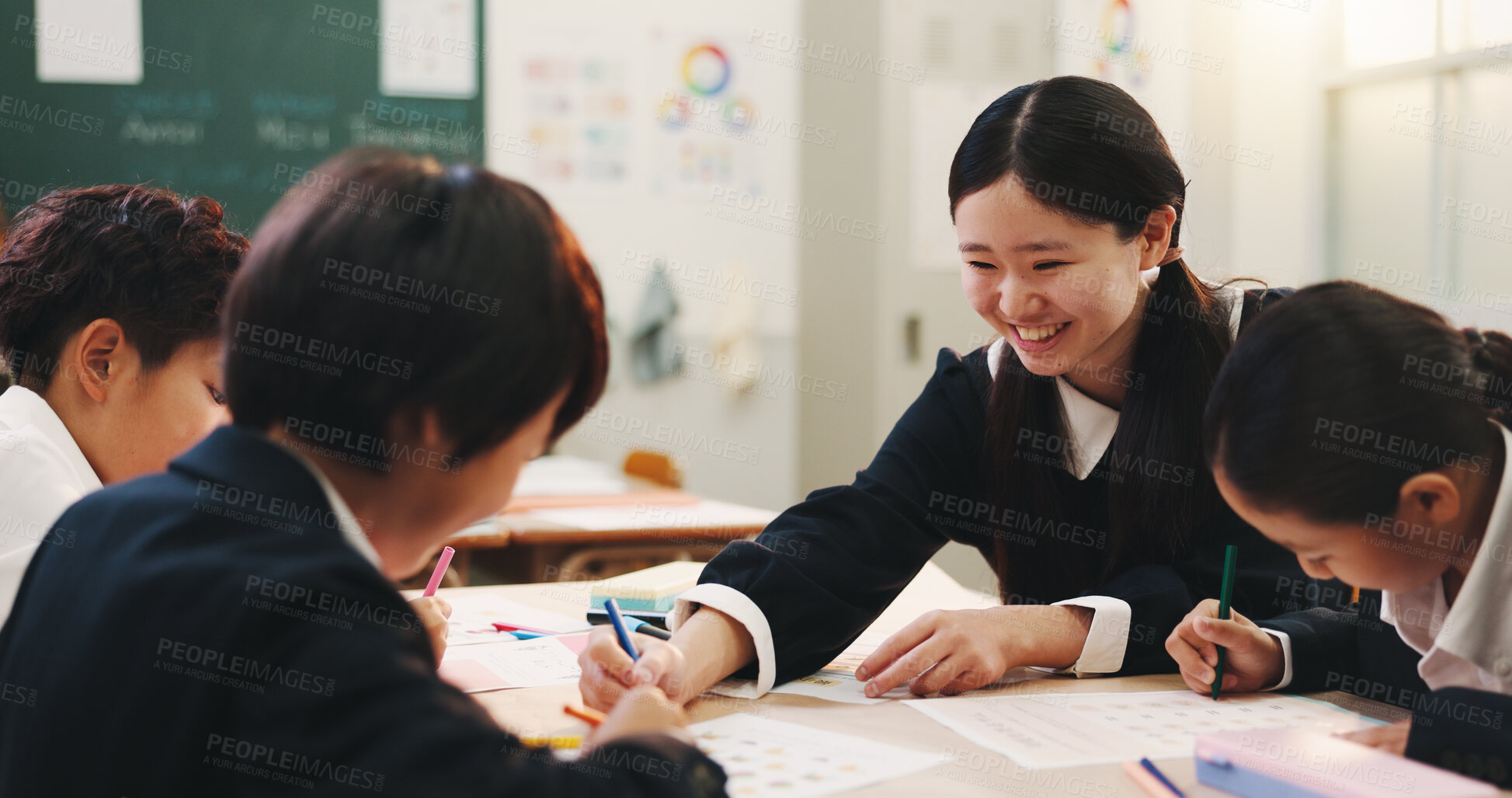 Buy stock photo Girl, group and studying in classroom with children, writing and happy with learning, help and progress for development. Kids, school and books for assessment, smile and tutor at academy in Japan