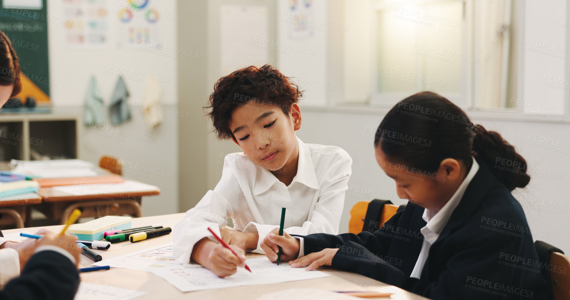 Buy stock photo Boy, children and group for learning in classroom, writing and color pencil for creativity, study or development. School kids, education and progress with paper, notes or together at academy in Japan