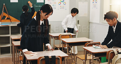 Buy stock photo Students, girl and cleaning desk at school for hygiene, learning responsibility and discipline in classroom. Japanese academy, people and wipe surface for disinfection, germs prevention and teamwork