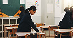 Student, child and cleaning desk at school for hygiene, learning responsibility and discipline in classroom. Japanese academy, people and wipe surface for disinfection, germs prevention and values