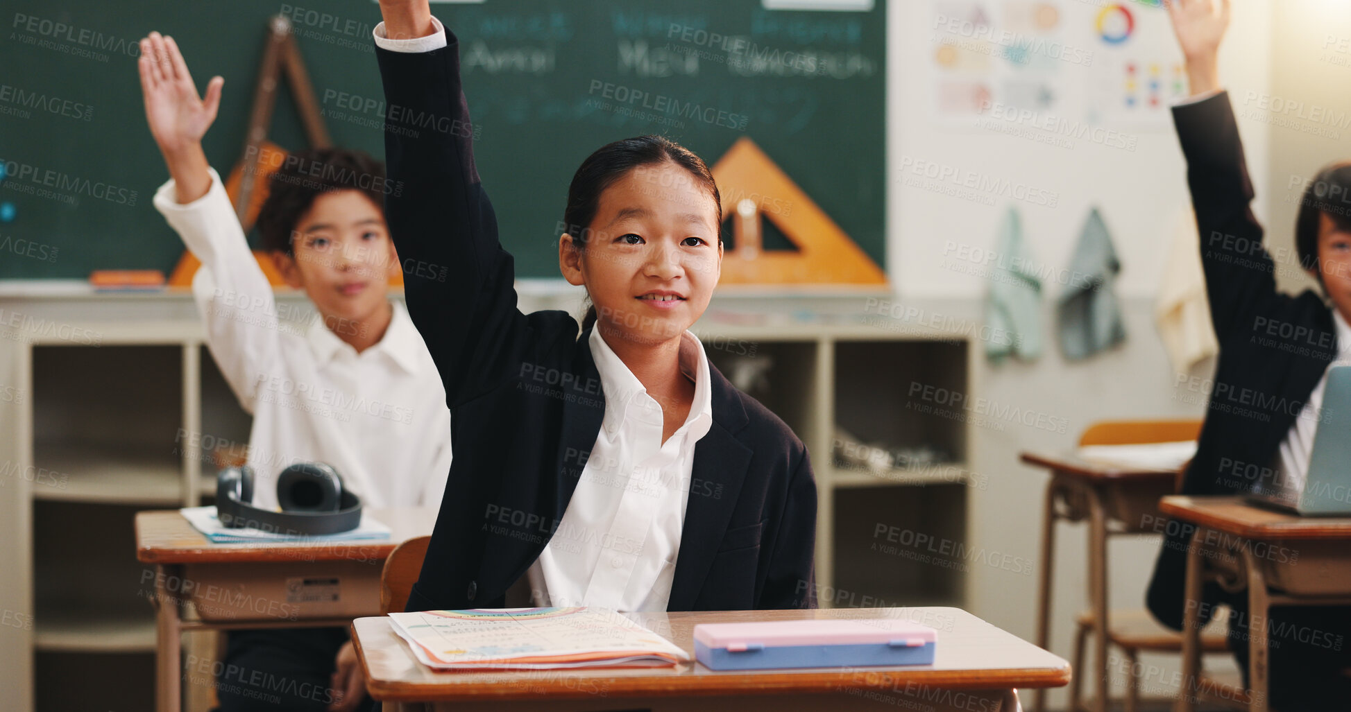 Buy stock photo Boy, raised hand and answer in classroom for learning, opinion and study with problem solving test. School kids, smile and sign for question, solution and progress with quiz at academy in Japan