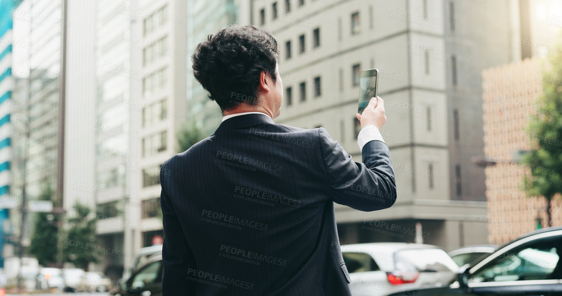 Buy stock photo Japanese businessman, city street and back with mobile phone for photography, streaming or travel. Male person, outdoor and technology as legal professional in morning commute, sightseeing and career