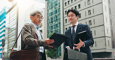 Buy stock photo Outdoor, teamwork and business people in city for documents, development or talking. Urban planner, handover and mature professional Japanese colleagues planning town project file together in Tokyo