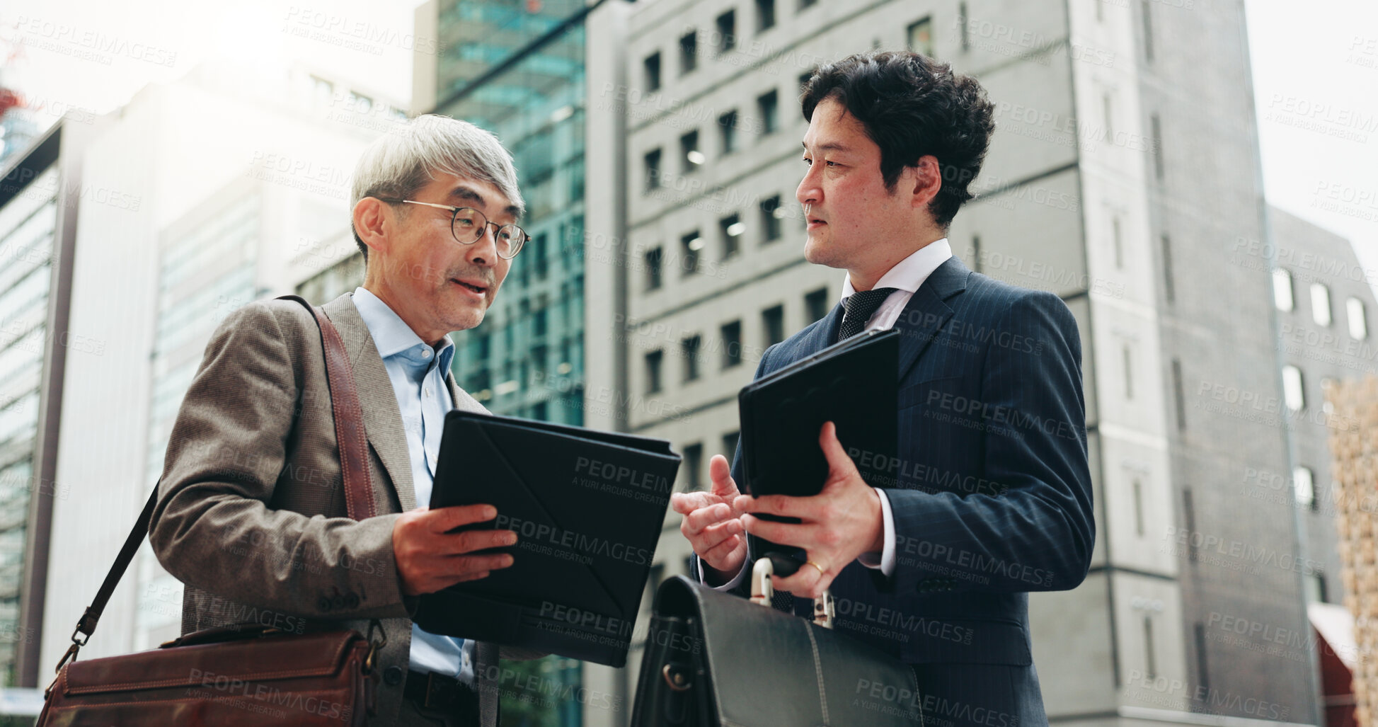 Buy stock photo Planning, teamwork and business people in city for documents, development or buildings. Developer, urban planner and mature professional Japanese colleagues speaking of project together in Tokyo