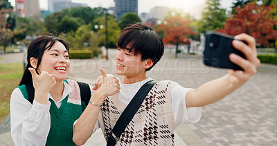 Buy stock photo Couple, happy and thumbs up in city for selfie, healthy relationship and excited for travel in Tokyo. Japanese people, influencers and like emoji in park for photography, app review and social media