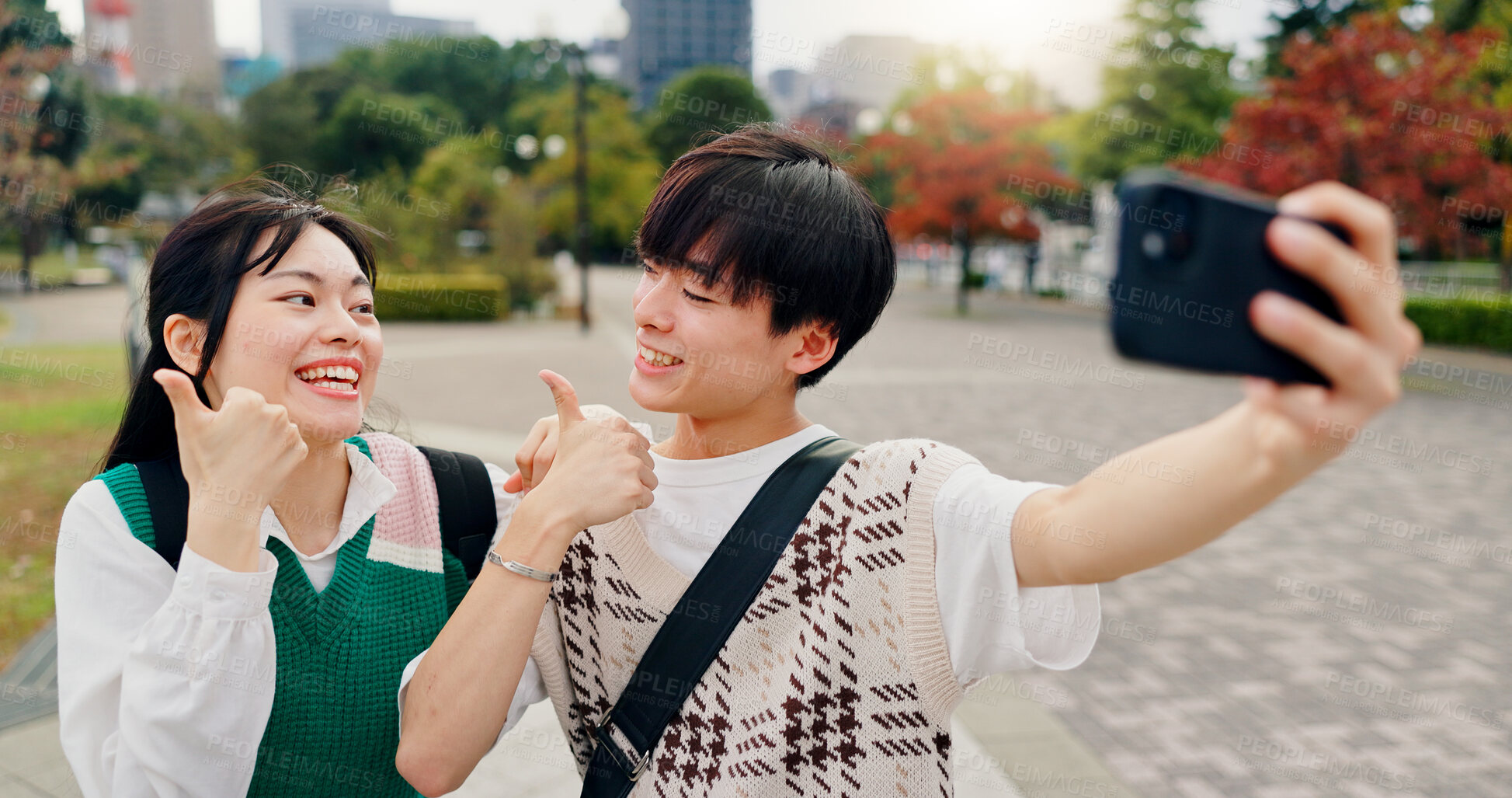 Buy stock photo Couple, happy and thumbs up in city for selfie, healthy relationship and excited for travel in Tokyo. Japanese people, influencers and like emoji in park for photography, app review and social media