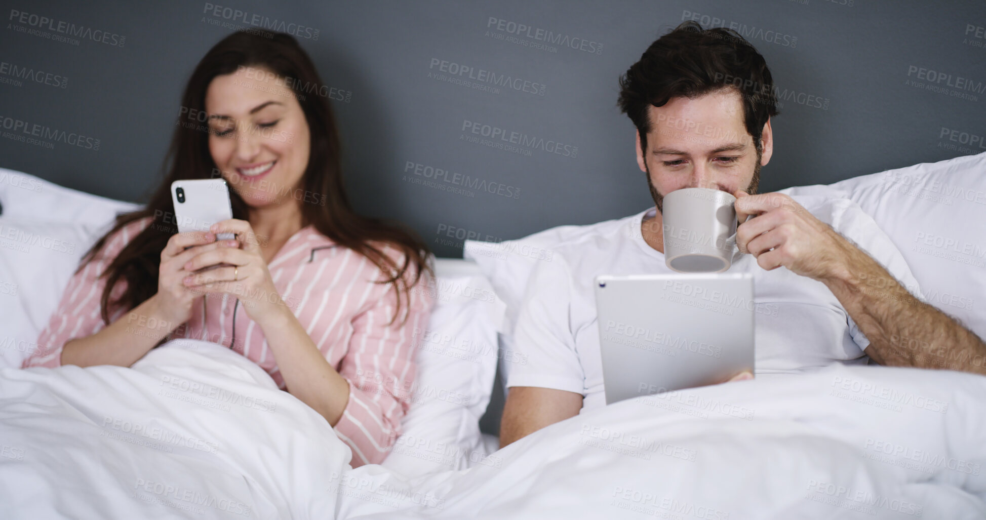 Buy stock photo Phone, tablet and couple in bed with coffee in home for networking, connectivity or browsing online. Happy, relax and people with cellphone and digital technology in bedroom for contact in house.