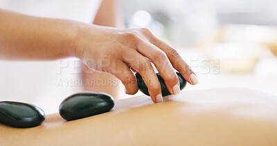 Buy stock photo Person, hands or massage with hot stones on back at spa for relaxation, release tension or stress relief. Closeup, masseuse and client with heated rocks for physical therapy, salon treatment or detox