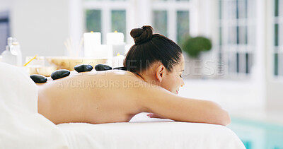 Buy stock photo Woman, relax or massage with hot stones on back at spa for release tension, stress relief or healing. Female person, sleeping or client with heat rocks on bed for physical therapy, treatment or detox