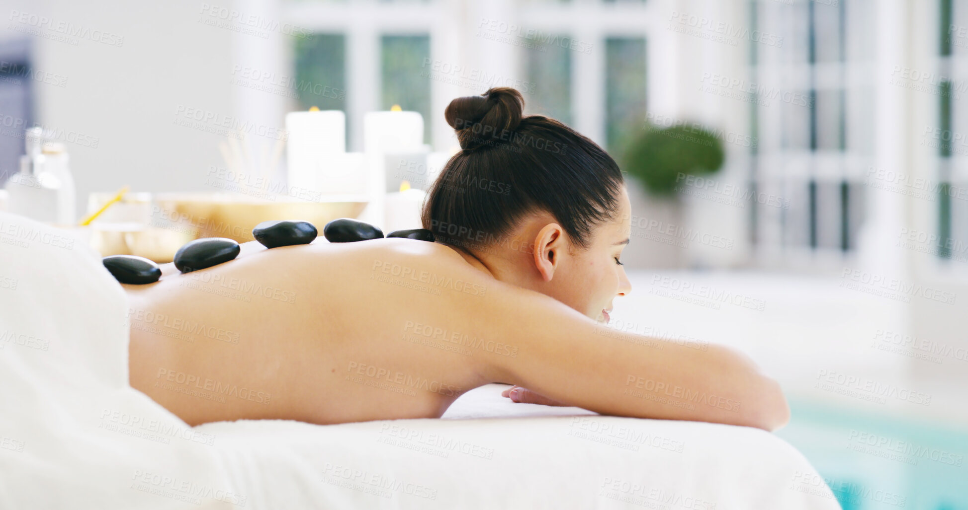 Buy stock photo Woman, relax or massage with hot stones on back at spa for release tension, stress relief or healing. Female person, sleeping or client with heat rocks on bed for physical therapy, treatment or detox