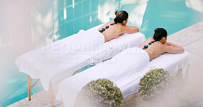 Buy stock photo Women, friends and relax at spa for stone massage for luxury, self care and wellness. People, customer and above on break or resting at resort for body therapy service, treatment or peace on vacation