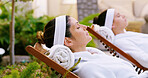 Resort, woman and relax in robe by spa for weekend break, stress relief or luxury treatment outdoor. Friends, person and resting at beauty lodge for wellness, comfort and self care on holiday getaway