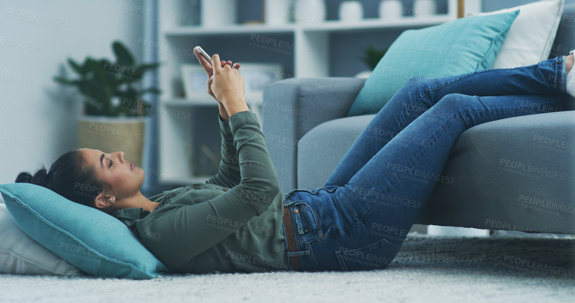 Buy stock photo Woman, phone and lying on floor in home, texting and relax by sofa with scroll, app or contact in lounge. Person, smartphone and pillow on carpet on break with virtual chat on social media in house