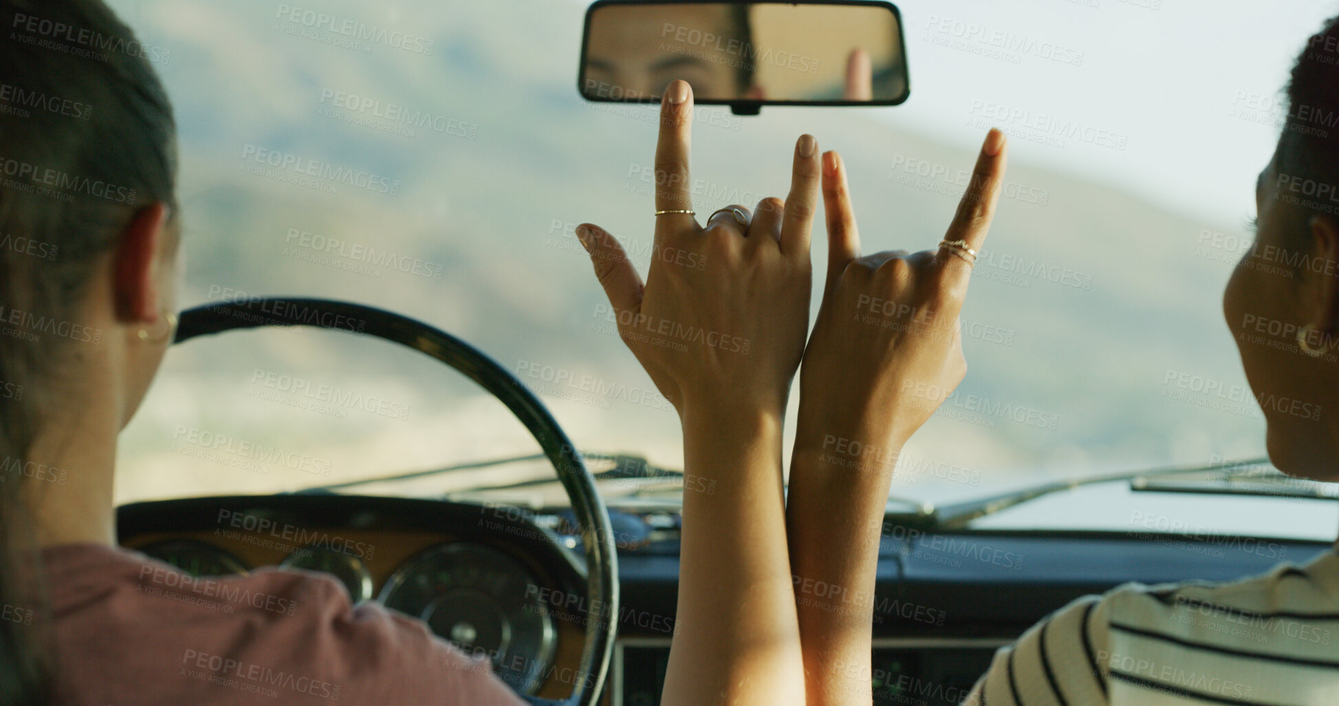 Buy stock photo Hands, road trip and horns sign with car, love and together for travel, connection and kindness on journey. People, driving and transport with friends on vacation with icon, symbol or emoji in street