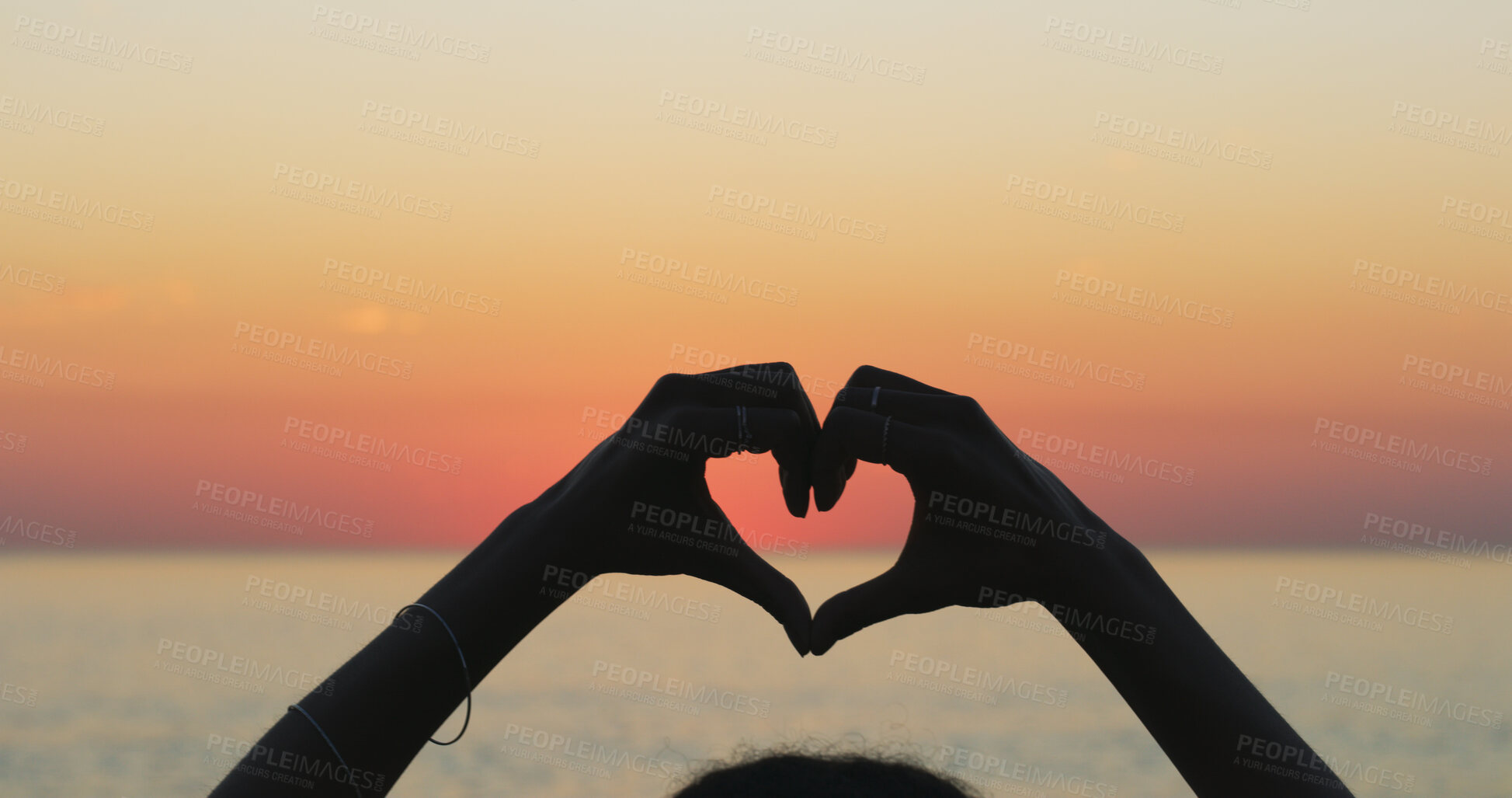 Buy stock photo Person, outdoor beach and heart hands at sunset, love and emoji for kindness on earth adventure. Horizon, dusk and fingers for gesture on vacation at sea, support ecology and care for tropical island