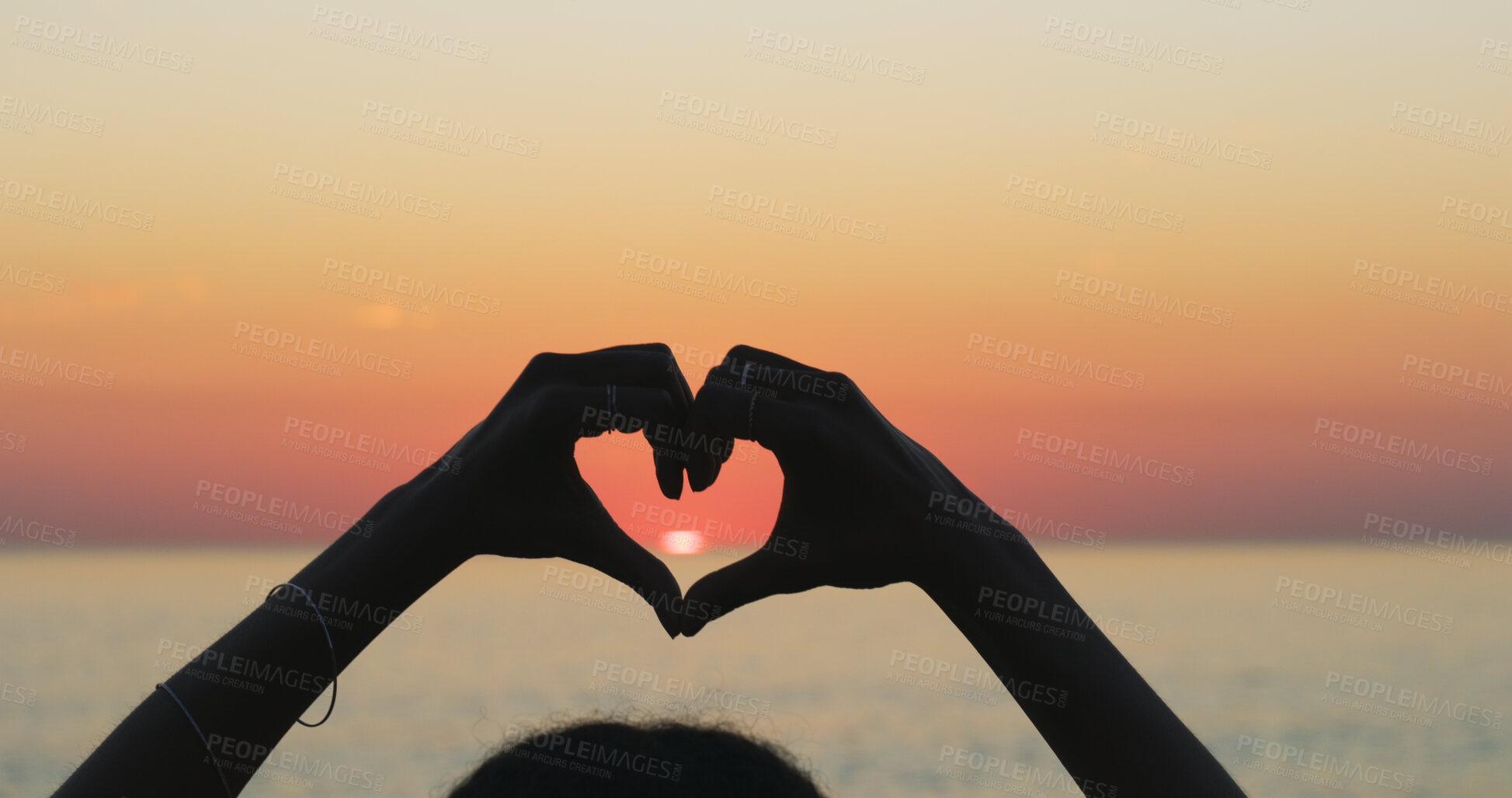 Buy stock photo Person, outdoor ocean and heart hands at sunset, love and emoji for kindness on earth adventure. Horizon, dusk and fingers for gesture on vacation at sea, support ecology and care for tropical island