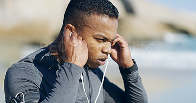 Buy stock photo Beach, man and tired with earphones for fitness, exercise and sprinter with workout music for wellness outdoor. Ocean, male person and runner with sweat for training, cardio and podcast with recovery