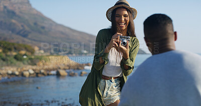 Buy stock photo Beach, couple and woman with camera for photography, capture memory and bonding with partner outdoor. Relationship, man and photographer with equipment for picture, laughing and adventure on vacation