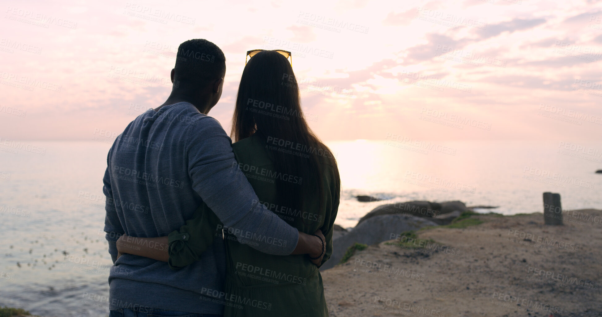 Buy stock photo Sunset, beach and couple in embrace on romantic date, holiday adventure or sightseeing from back. Evening sky, man and woman on travel vacation with love, view or outdoor journey together at ocean