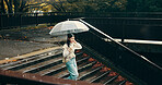 Umbrella, stairs and woman in city walking in rain on vacation for exploring, adventure or fun. Winter season, steps and female person commuting in urban town on holiday or weekend trip in Japan.