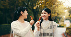 City, asian women and happy with candy, travel and snack for friends with dango, students and road. Outdoor, commuting and sweets for celebration of reunion, smile and sharing of food in Japan