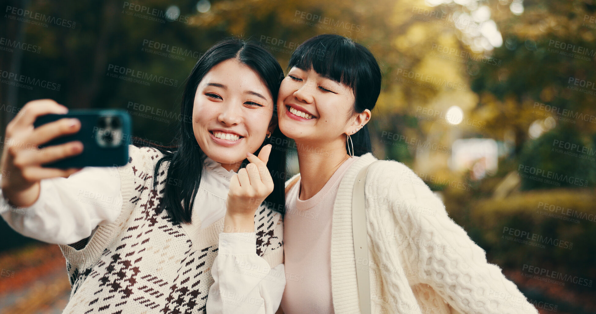 Buy stock photo Japanese, women and park with selfie for photography, vacation memory and bonding with hand sign. Happy people, friends and photographer with smile for social media, profile picture and finger heart