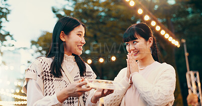 Buy stock photo Outdoor, asian women and happy with candy, sharing and snack for friends in city, gratitude and road. Treat, commuting and sweets for celebration of reunion, smile and thank you for food in Japan