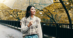 Japanese woman, winter and outdoor with thinking, planning and umbrella in garden or park. Female person, happy and biology student at university for relax, ideas and beauty in nature or countryside