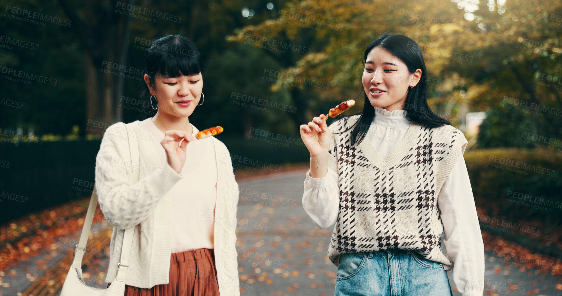 Buy stock photo Park, asian women and happy with candy, travel and snack for friends with dango, students and road. Outdoor, commuting and sweets for celebration of reunion, smile and sharing of food in Japan