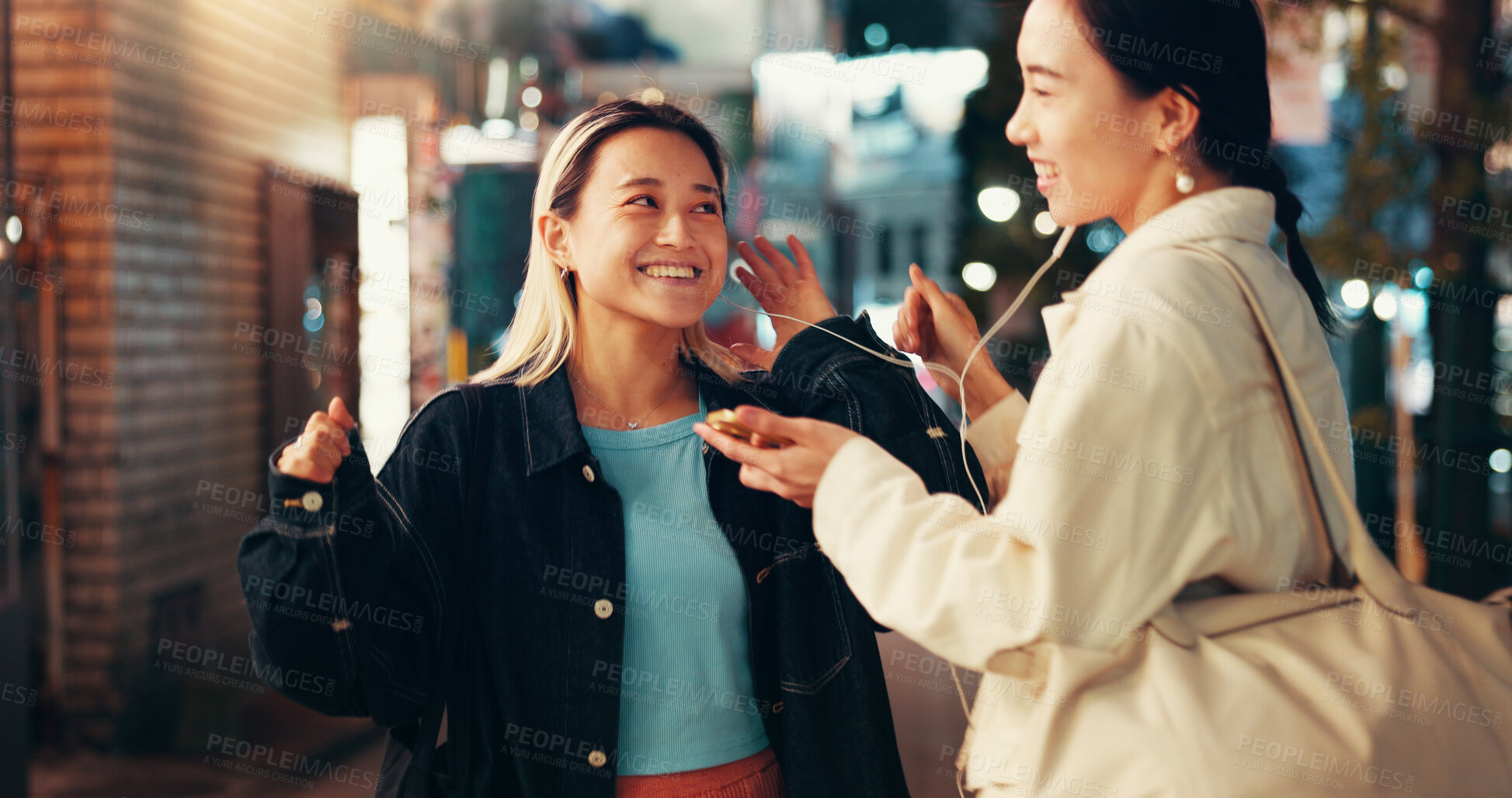 Buy stock photo Earphones, music and smile with Japanese people in city for streaming, online playlist and radio. Happiness, bonding and podcast with asian friends listening to audio at night for album and support