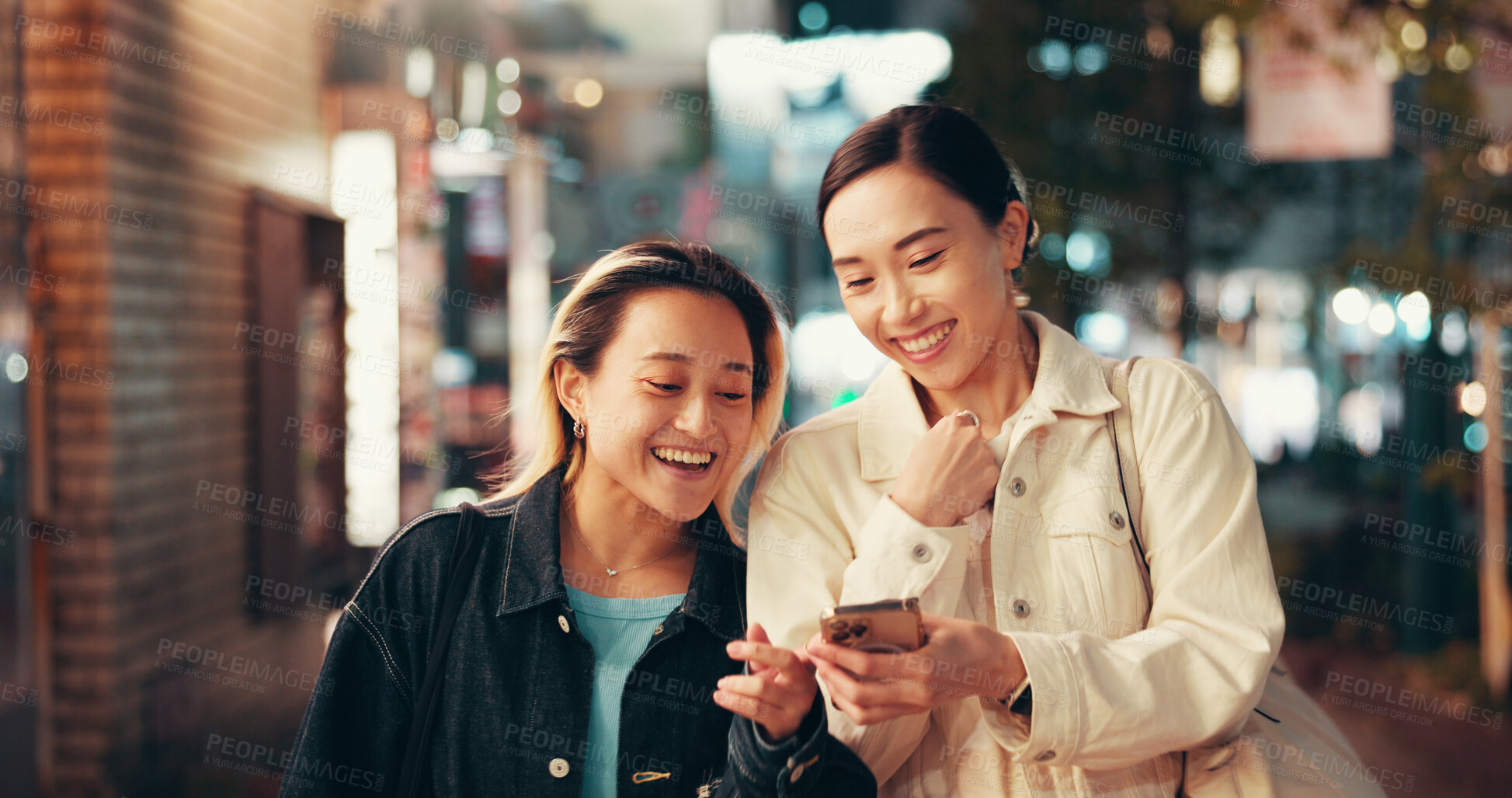 Buy stock photo Happy, asian women and night with phone in city for social media, communication or network. Japan, female people or friends with mobile smartphone for online chatting, texting or app in an urban town