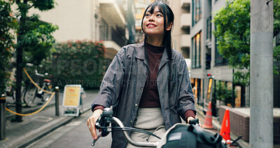 Buy stock photo Travel, buildings and Asian woman on bicycle in city for morning commute, adventure or journey outdoors. Location, cycling and person on bike for trip, sustainable and eco friendly transport in Japan