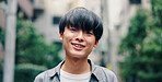 City, happy and portrait of Asian man in road for university, education and morning commute to college. Travel, urban town and face of person smile for holiday, break and weekend in Japan outdoors