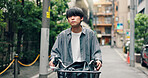 Travel, street and Asian man with bicycle in city for commute, adventure and journey outdoors. Trip, cycling and person on bike for carbon footprint, sustainable and eco friendly transport in Japan