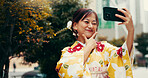 Selfie, wink and kimono with Japanese woman in city for profile picture, memory and traditional clothes. Travel, social media post and content creator with person for heritage, culture and update