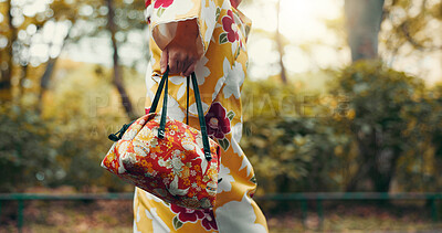 Buy stock photo Asian woman, hands and walking with kimono or bag in nature for travel, tradition or culture. Japan, closeup and strolling with stylish fashion, luggage or handbag for tourism or commute at park