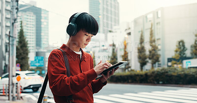 Buy stock photo City, headphones and man in street with tablet, morning commute or online search on crosswalk. Urban travel, pedestrian crossing and Japanese university student on digital app for music streaming